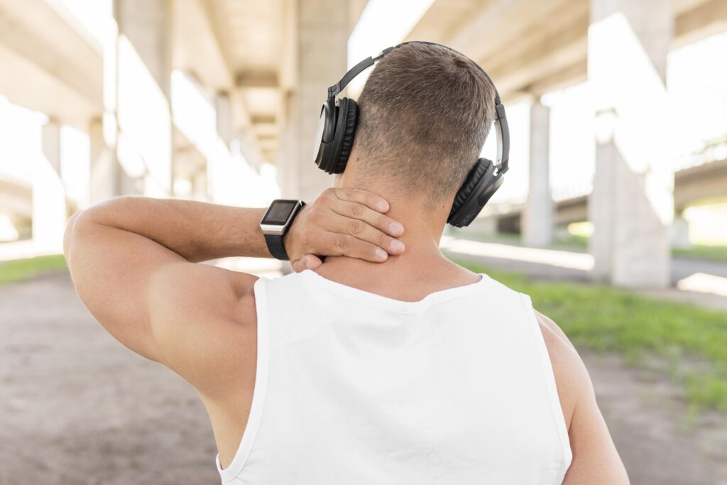 vista-posteriore-uomo-che-ascolta-la-musica-tramite-le-cuffie-prima-dell-allenamento